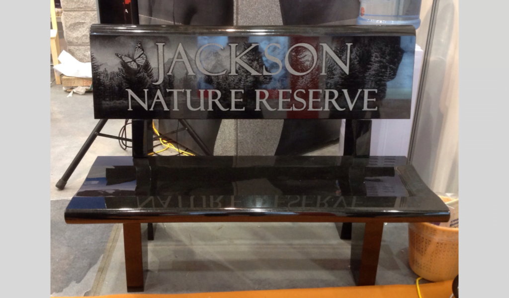 Black Granite Bench With “Jackson Nature Reserve” Laser-Engraved, Featuring Nature-Themed Artwork.