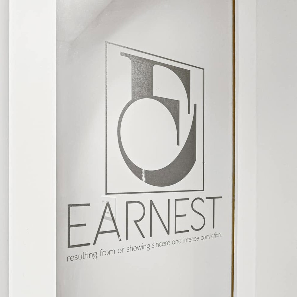 A business logo engraved on a glass door.