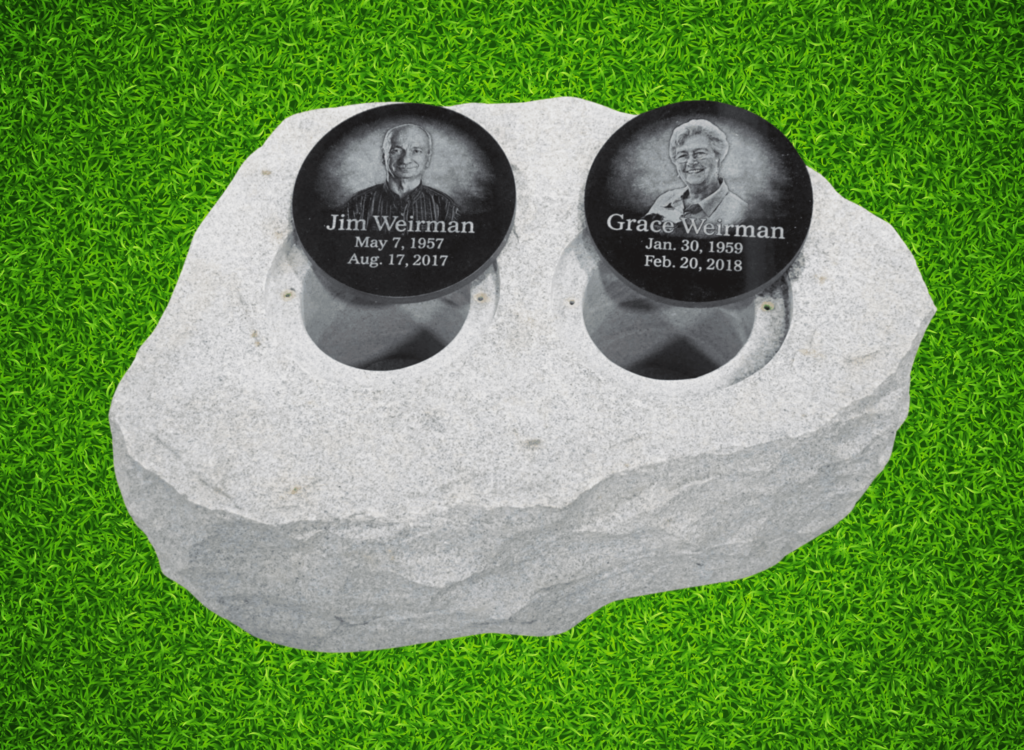 A boulder rock is crafted into a double cremation garden urn with two chambers, featuring laser-engraved black granite covers with portraits.(the covers are open to show chambers.)