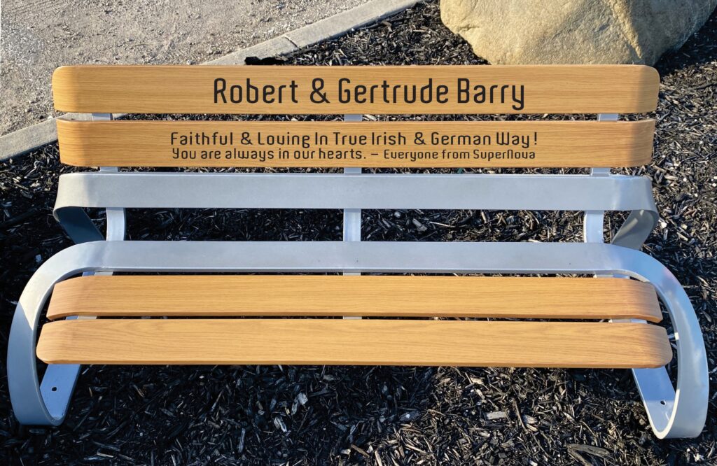 A wooden park bench engraved by an AP Lazer machine as a memorial gift.